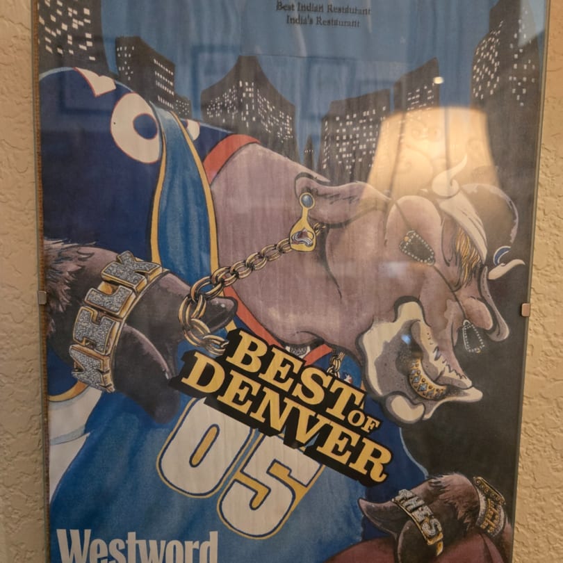 A framed "Best of Denver" award for India's Restaurant, featuring a cartoon elephant.